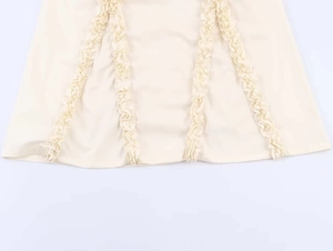 Gedetailleerd beeld van de gelaagde ruchezoom op deze elegante beige midi zomerjurk dames