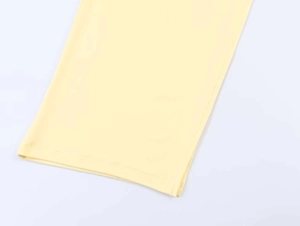 Close-up of light yellow knit fabric showing detailed stitching and smooth texture