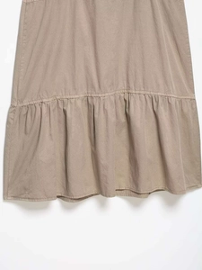 Detail of khaki midi dress featuring a ruffled hem and fine cotton fabric texture