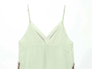Close-up of mint green satin camisole dress with contrast dark brown lace trim detail