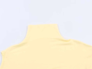 Detail of soft pale yellow knit high collar and fabric texture of a sleeveless top
