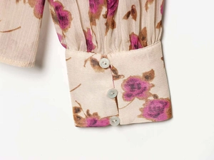 Detail view of vintage floral print chiffon blouse cuff with three elegant pearl buttons