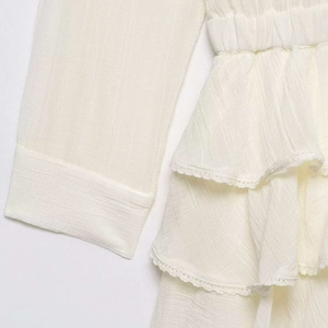 Chic ivory tiered tulle dress featuring delicate lace trim and textured vertical stripes