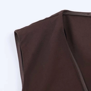 Detail of V-neck brown sleeveless vest showing stitching and fine twill fabric texture