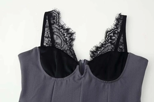 Detalle de vestido gris oscuro con ribete de encaje de pestañas negro y copas de raso