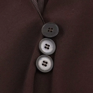 Close-up of brown twill vest featuring black buttons and ribbed edge binding detail