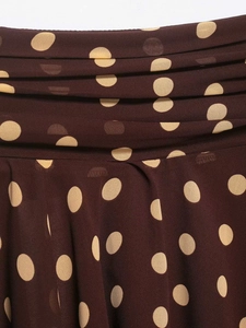 Detailed macro view of chiffon polka dot skirt with pleated waist and brown fabric