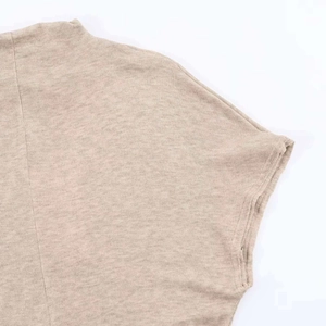 Detail view of beige knit maxi dress showing high neck and fine ribbed fabric texture