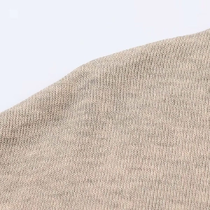 Macro shot of breathable oatmeal knitted fabric texture for a minimalist summer maxi dress