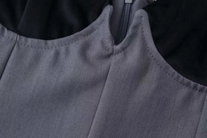 Detalle del escote en V profundo con encaje de pestañas y cremallera invisible