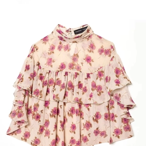 Floral ruffle blouse in apricot chiffon featuring delicate rose print and high neckline