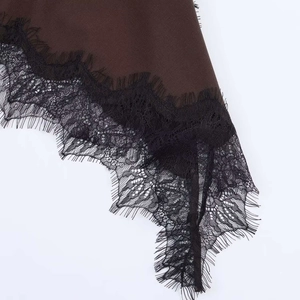 Close-up of brown fabric with delicate black eyelash lace trim and refined stitching