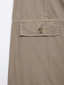 Detail of khaki twill fabric with a flap pocket and dark brown tortoise button