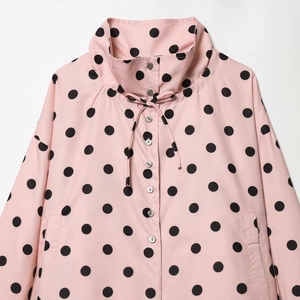 Detail of pink polka dot jacket showing stand-up collar with adjustable drawstring