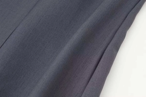 Detalle de tela tejida gris oscuro con textura de sarga fina y costuras de alta calidad