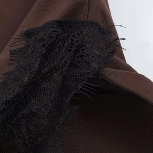 Detailed close-up of brown twill fabric with black eyelash lace trim on a V-neck vest