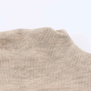 Macro detail of the beige ribbed knit fabric texture on the casual maxi dress