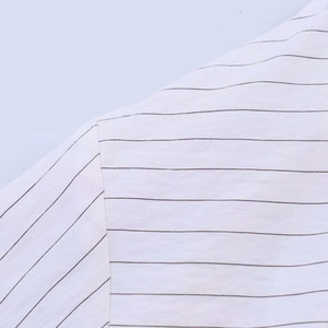 Gros plan sur la couture et les fines rayures noires sur le tissu en coton blanc
