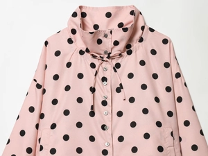 Detail of pink polka dot long sleeve blouse with lace-up collar and button closure