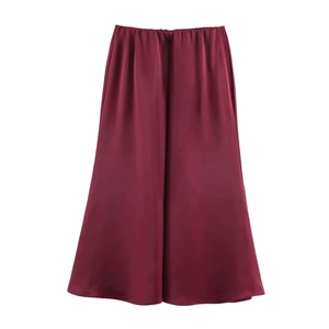 Detailed view of burgundy satin midi skirt featuring elastic waist and silky texture