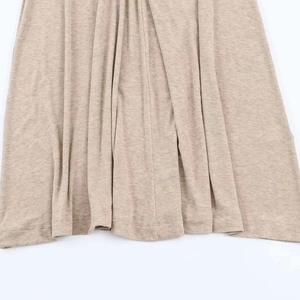 Detailed macro view of khaki knit fabric texture and draped hemline on a maxi dress