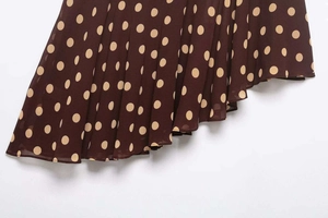 Detailed close-up of brown polka dot chiffon skirt featuring asymmetrical ruffled hemline