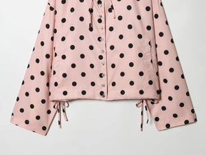 Pink polka dot hooded jacket detail with black buttons and drawstring hem design
