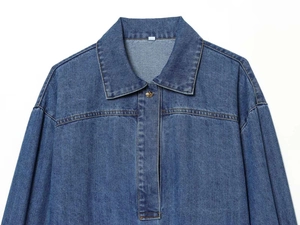 Détail de la texture d'une chemise en jean bleue avec bouton en métal et manche lanterne