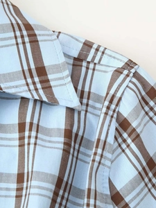 Détails du motif à carreaux bleu et marron sur le col d'une chemise en coton