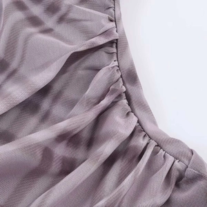 Detail der lilafarbenen gerafften Netzoberfläche mit dezentem Tie-Dye-Muster am Kleid
