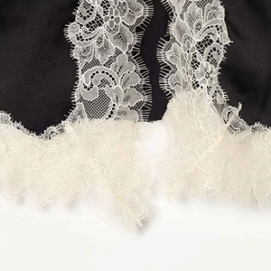Mini-jupe élégante en satin noir avec ourlet délicat en dentelle de cils blanche