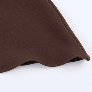 Detail shot of the ruffled hem and premium textured fabric on chocolate brown tank top
