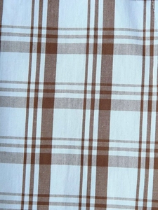 Gros plan sur la texture du tissu à carreaux marron et blanc en coton mélangé