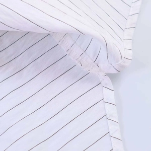 Vue macro des coutures fines et rayures sombres sur le tissu blanc respirant