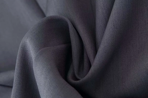 Detalle del tejido de encaje de pestañas gris carbón con textura de sarga fina
