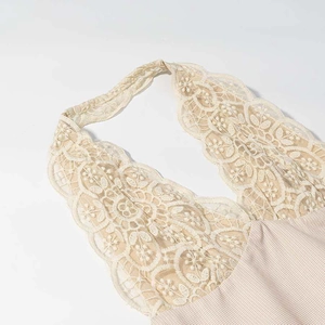 Detail of floral lace embroidery and checkered fabric on a halter mini dress