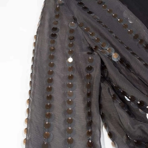Détail de tissu en mesh gris foncé avec décorations de paillettes rondes scintillantes