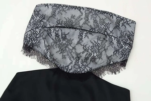 Close-up of black eyelash lace trim on premium satin dress with detailed embroidery