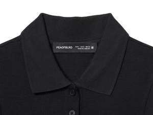 Detail of black polo collar and knitted rib texture with sewn-in brand woven label