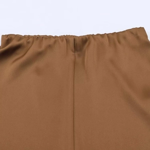Macro detail of brown satin skirt waist with elastic band and smooth silk texture