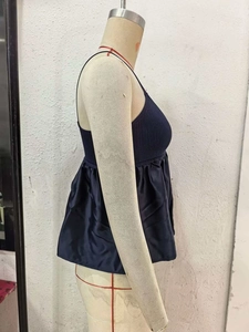 Detail of navy blue camisole showing ribbed knit bodice and satin pleated hem on mannequin