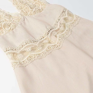 Detailed view of hollow floral lace stitching and fine checkered texture on beige dress