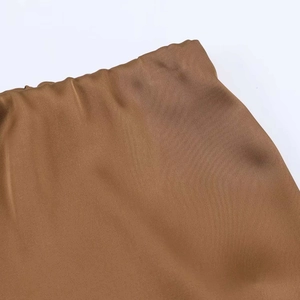 Detailed view of the brown satin skirt featuring a premium silky texture and elastic waist