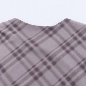Detail von Rundhalsausschnitt und kariertem Netzstoff an einem Faltenkleid