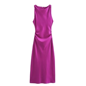 Detalle de los lados fruncidos en un vestido midi de satén fucsia con acabado sedoso