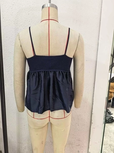 Detail of dark blue knit tank top with spliced satin fabric and thin straps on back view