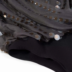 Gros plan sur un tissu plissé gris foncé avec paillettes décoratives et doublure noire