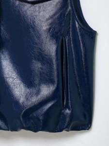 Détail d'une veste en cuir synthétique bleu foncé avec poche et ourlet élastique chic