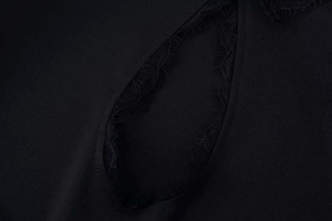 Detailed macro view of a teardrop cutout neckline with elegant black eyelash lace trim