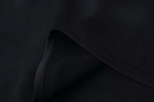 Detail view of high-quality black satin fabric with fine stitching and smooth texture